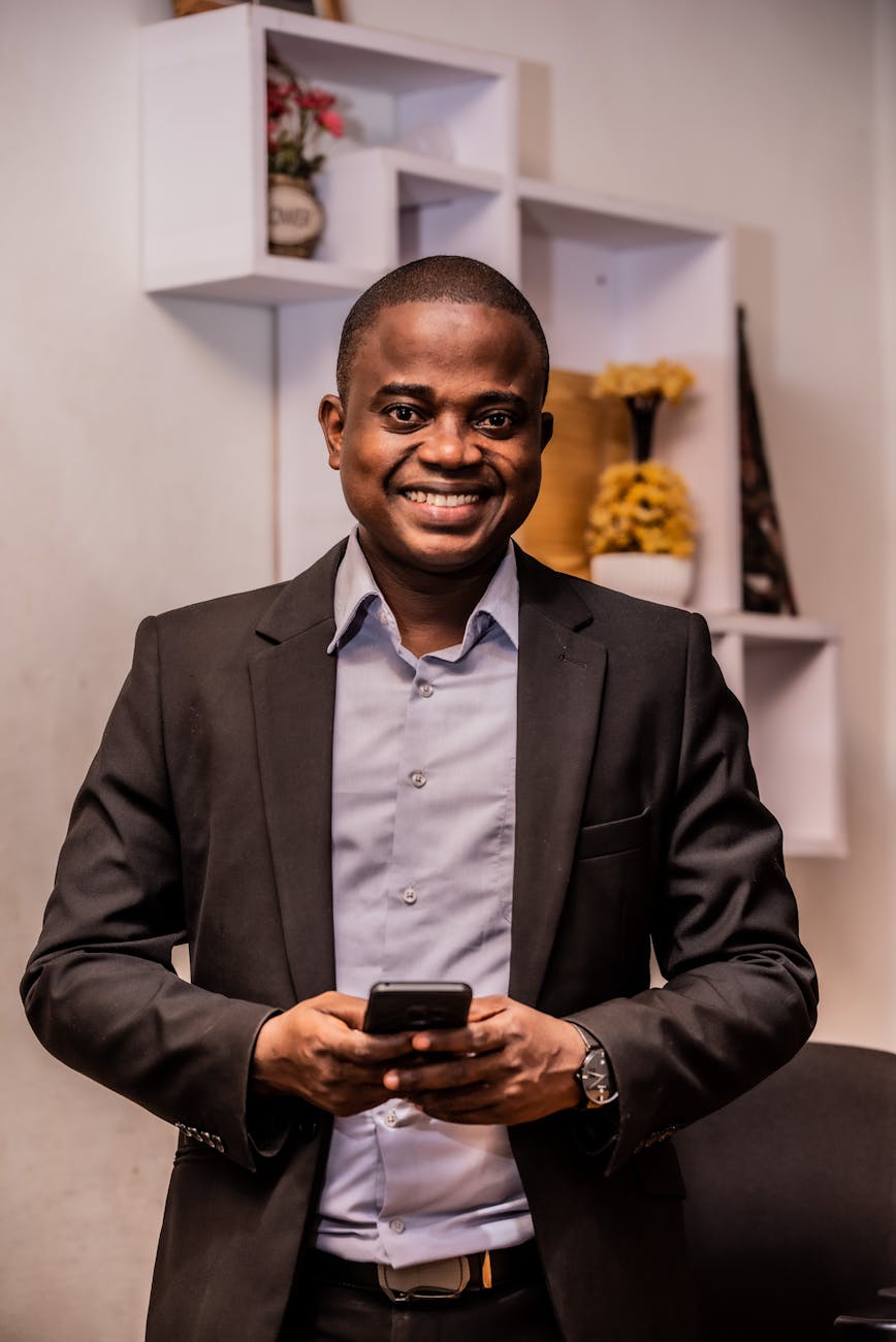 a man in black suit jacket holding a cellphone