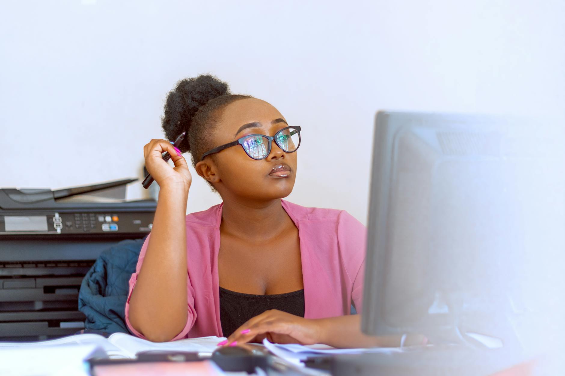 photo of a woman with eyeglasses working on her computer