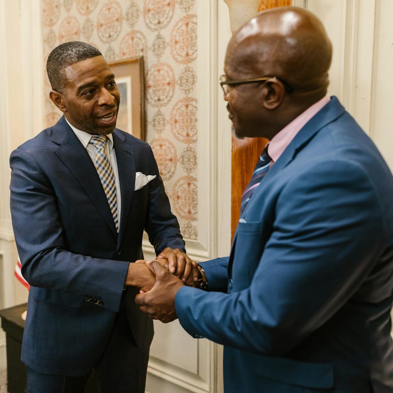 a two men talking while holding hands