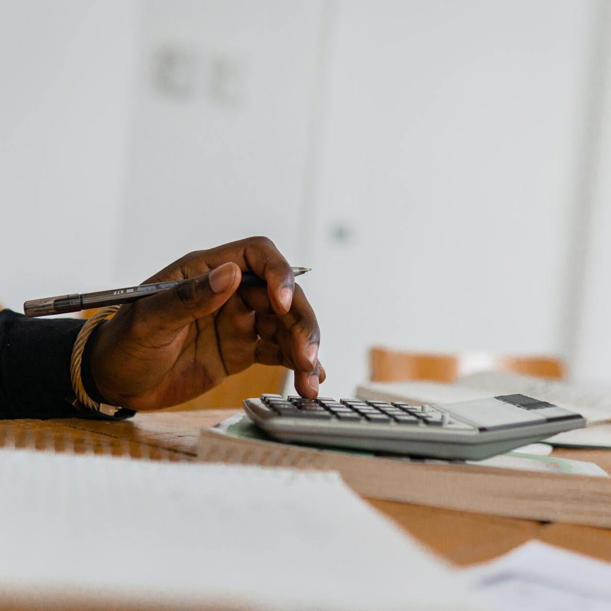 a person using a calculator while holding a pen